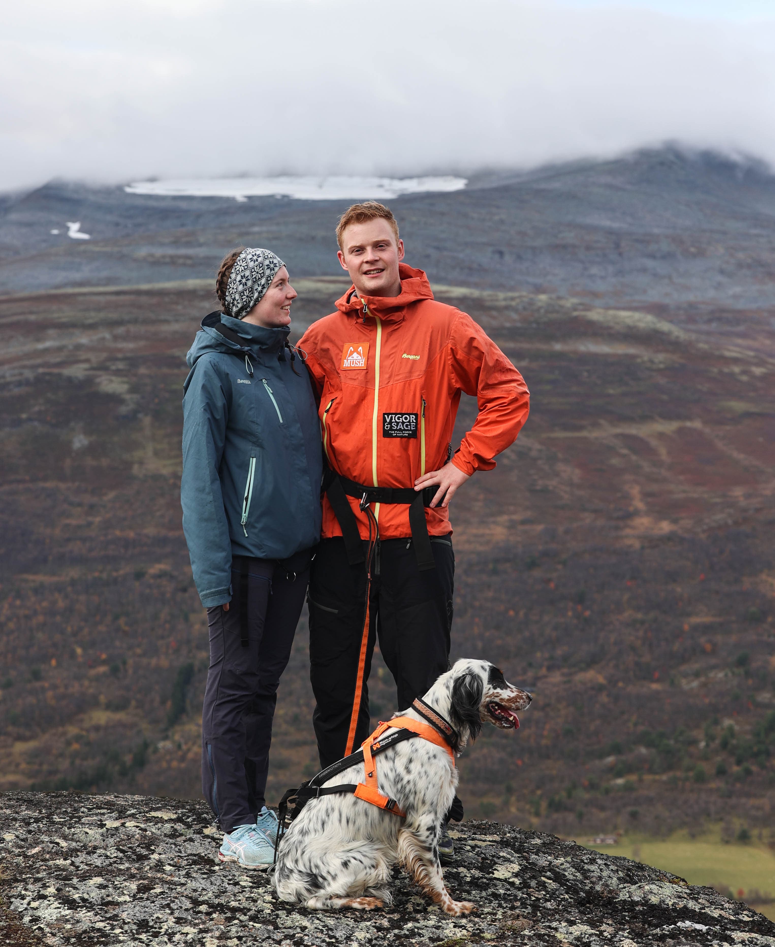 Kristine, Ola og en hund på fjelltur med lave skyer over landskapet